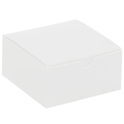Industrial-strength white fibreboard gift boxes sized 4x4x2 inches with convenient one-piece construction that sets up in seconds. Case of 100 units ships and stores flat, reducing warehouse costs and shipping expenses. Gray interior contrasts with white exterior for professional retail and novelty packaging.